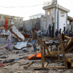 Bystanders walk through the scene of bombing at a seaside restaurant at Liido beach in Mogadishu, Somalia April 23, 2022. REUTERS/Feisal Omar