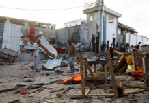 Bystanders walk through the scene of bombing at a seaside restaurant at Liido beach in Mogadishu, Somalia April 23, 2022. REUTERS/Feisal Omar