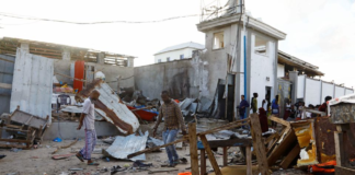 Bystanders walk through the scene of bombing at a seaside restaurant at Liido beach in Mogadishu, Somalia April 23, 2022. REUTERS/Feisal Omar