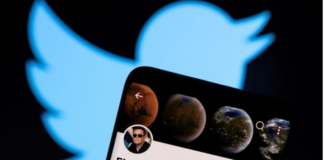 Elon Musk's twitter account is seen on a smartphone in front of the Twitter logo in this photo illustration taken, April 15, 2022. REUTERS/Dado Ruvic/Illustration/File Photo