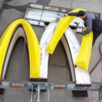 A worker dismantles the McDonald's Golden Arches logo at a drive-through restaurant in Kingisepp, Russia.