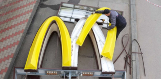 A worker dismantles the McDonald's Golden Arches logo at a drive-through restaurant in Kingisepp, Russia.