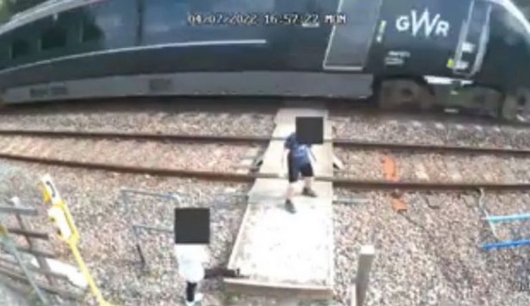Shocking as CCTV footage captures children dancing on tracks in front of oncoming train as adults watch