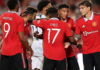Jadon Sancho celebrates with his team-mates after scoring their first goal against Liverpool