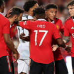 Jadon Sancho celebrates with his team-mates after scoring their first goal against Liverpool