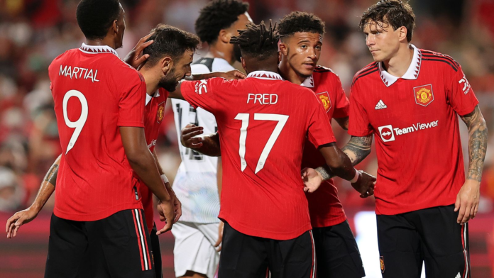 Jadon Sancho celebrates with his team-mates after scoring their first goal against Liverpool