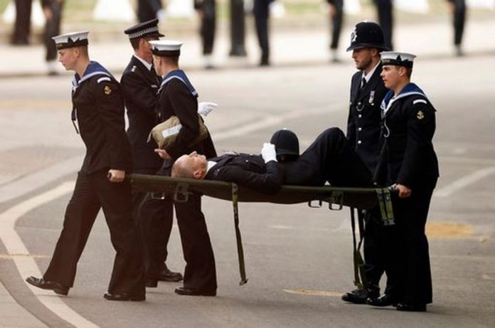 The police officer was stretchered away after collapsing ( Image: REUTERS)