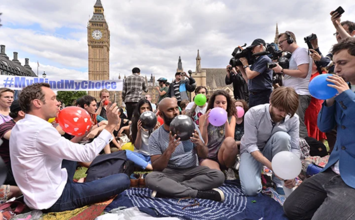 People taking part in a mass inhalation of nitrous oxide outside the Houses of Parliament in protest against the plan to crackdown on legal highs on Aug. 1, 2015 in London, England. Ray Tang/REX Shutterstock