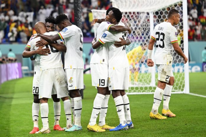 Ghana's midfielder #10 Andre Ayew (L) celebrates with teammates after scoring his team's first goal during the Qatar 2022 World Cup Group H football match between Portugal and Ghana at Stadium 974 in Doha on November 24, 2022. (Photo by MANAN VATSYAYANA / AFP) (Photo by MANAN VATSYAYANA/AFP via Getty Images) FIFA World Cup