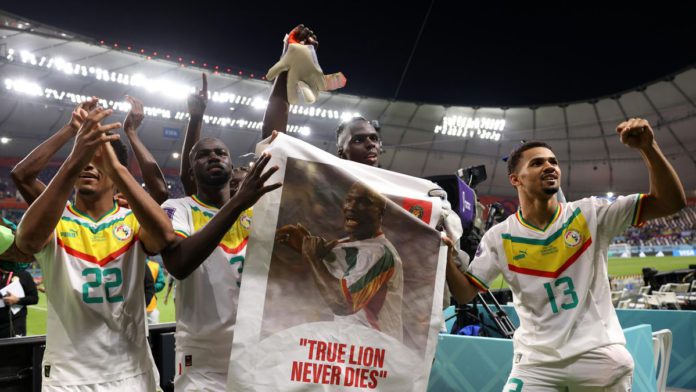 Senegal players applaud fans with a banner of Papa Bouba Diop, on the 2nd anniversary of his death, after their 2-1 victory in the FIFA World Cup Qatar 2022 Group A match between Ecuador and Senegal at Khalifa International Stadium on November 29, 2022 Image credit: Getty Images