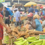Makola market, Accra: Woman buying yams on a partly cloudy day | photo taken by Adomonline's Dennis K. Adu