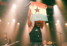 King Promise projects a Ghana flag during one of his 5 Star world tour performances in Europe