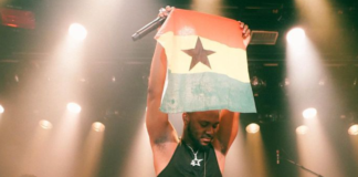 King Promise projects a Ghana flag during one of his 5 Star world tour performances in Europe