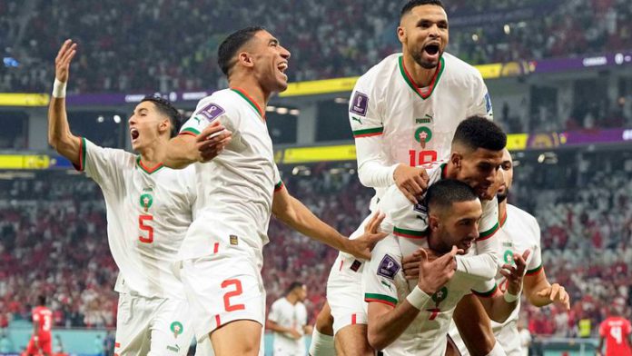 Morocco's Hakim Ziyech is mobbed after scoring the opening goal