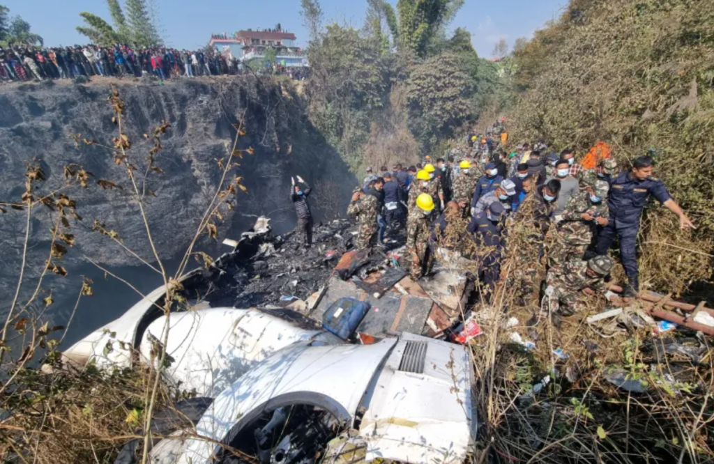 Rescue teams work to retrieve bodies at the crash site [Bijay Neupane/Handout via Reuters]