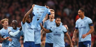 Ivan Toney of Brentford and teammates hold a shirt for former teammate Sergi Canos after scoring the team's first goal during the Premier League match between Arsenal FC and Brentford FC at Emirates Stadium on February 11, 2023 in London, England. Image credit: Getty Images