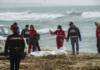 Italian Red Cross volunteers and coast guards recover a body after a migrant boat broke apart in rough seas, at a beach near Cutro, southern Italy, on Feb. 26, 2023. AP/Antonino Durso/LaPress