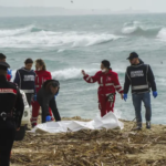 Italian Red Cross volunteers and coast guards recover a body after a migrant boat broke apart in rough seas, at a beach near Cutro, southern Italy, on Feb. 26, 2023. AP/Antonino Durso/LaPress