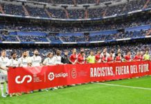 Real Madrid and Rayo Vallecano players held a banner saying "racists out of football" in support of Vinicius Jr before Wednesday's La Liga match at the Bernabeu