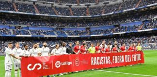 Real Madrid and Rayo Vallecano players held a banner saying "racists out of football" in support of Vinicius Jr before Wednesday's La Liga match at the Bernabeu