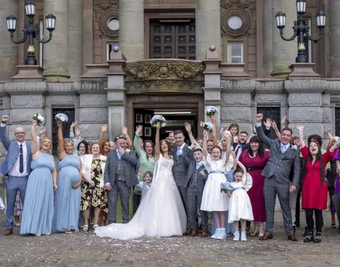 The couple and their friends and family on the big day ( Image: Clarity Wedding Photography / SWNS)