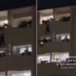 The victim hanging on the building while his colleagues are trying to save him