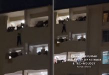 The victim hanging on the building while his colleagues are trying to save him