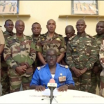 Niger army spokesperson Colonel-Major Amadou Adramane speaks during an appearance on national TV after President Mohamed Bazoum was held in the presidential palace, in Niamey, Niger, July 26, 2023, in this still image taken from video [ORTN via Reuters]