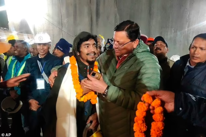 Pushkar Singh Dhami, right, Chief Minister of the state of Uttarakhand, greets a worker rescued from the tunnel in Silkyara, India, Tuesday, November 28, 2023