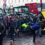 A person throws eggs towards the police officers as Belgian farmers use their tractors to block the European Union headquarters, as they protest over price pressures, taxes and green regulation, grievances shared by farmers across Europe, on the day of the EU summit in Brussels, Belgium February 1, 2024. REUTERS