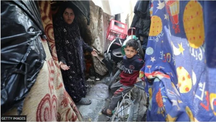 A woman and child stand among makeshift tents at Jabalia refugee camp in northern Gaza
