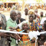Kofi Dzamesi (2nd from left), CEO of Bui Power Authority, being assisted by some traditional rulers to perform the tape-cutting ceremony. Inset: The new classroom block