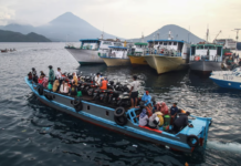 People travel on a wooden boat with motor scooters to Tidore Island ahead of Eid al-Fitr, which marks the end of the Muslim fasting month of Ramadan, at Bastiong port in Ternate, North Maluku, on 7 April 2024. Azzam Risqullah / AFP