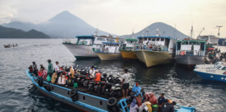 People travel on a wooden boat with motor scooters to Tidore Island ahead of Eid al-Fitr, which marks the end of the Muslim fasting month of Ramadan, at Bastiong port in Ternate, North Maluku, on 7 April 2024. Azzam Risqullah / AFP