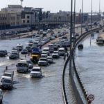 Vehicles drive through floodwater caused by heavy rain in Dubai on Thursday. Christopher Pike/AP