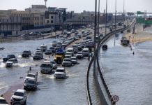 Vehicles drive through floodwater caused by heavy rain in Dubai on Thursday. Christopher Pike/AP