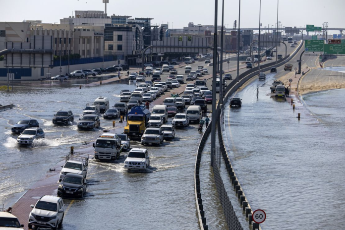 Vehicles drive through floodwater caused by heavy rain in Dubai on Thursday. Christopher Pike/AP