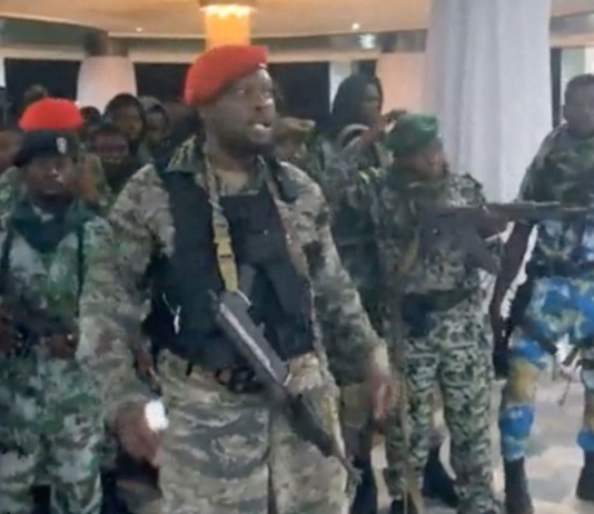 A man in military fatigues speaks as others stand next to him inside the Palace of the Nation during an attempted coup in Kinshasa, Democratic Republic of Congo, May 19, 2024, in this screen grab from a social media video. Christian Malanga/Reuters
