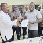 Benjamin Arthur (left), Chief Executive of FWSC, handing over the conditions of service to Prof. Mamudu Akudugu, UTAG National President