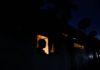 Several communities experience power outage in Western Region after high tension pole breaks at Half Assini A man looks out from a window while talking to a person during the power cut in Colombo, Sri Lanka March 30, 2022. REUTERS/Dinuka Liyanawatte