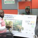Adom FM Presenter Ampofo Adjei presenting 50” smart android NASCO TV to Christiana Oduman in 1st monthly draw