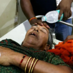 A staff member pours water on the face of a patient suffering from heat stroke in a hospital in Varanasi