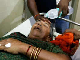 A staff member pours water on the face of a patient suffering from heat stroke in a hospital in Varanasi