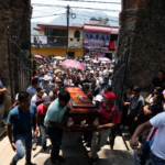 People carry a coffin that contains the remains of a man slain in a mass shooting into a church for a funeral service in Huitzilac, Mexico, on May 14. Fernando Llano/AP