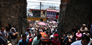 People carry a coffin that contains the remains of a man slain in a mass shooting into a church for a funeral service in Huitzilac, Mexico, on May 14. Fernando Llano/AP