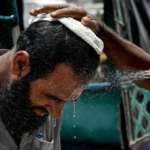 Getty Images In Karachi, a man has his face sprayed on to cool off during a heat wave