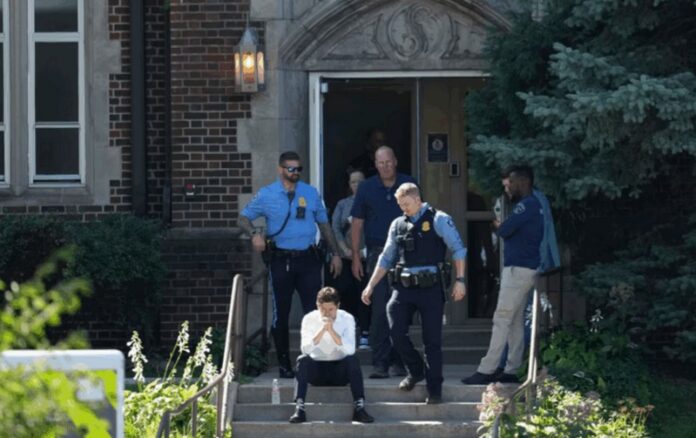 Minneapolis Mayor Jacob Frey sits on the steps of the Annunciation Church's school on Wednesday.