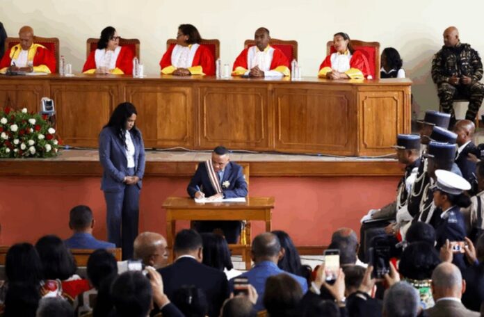 Madagascar's new military ruler, Colonel Michael Randrianirina, signs documents after being sworn in as president on Friday