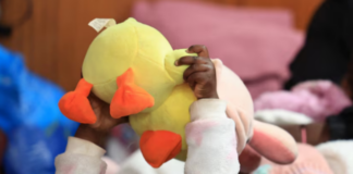 A migrant child plays with her toy while sheltering in a hall with her family, following an escalation in anti-immigrant protests, in Kleinmond, South Africa