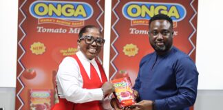Diana Antwi Hamilton being presented with a satchet of Onga Tomato Mix